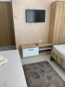 a room with two beds and a television on the wall at Eliksir in Gornja Trepča