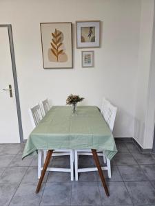 uma mesa de jantar com uma toalha de mesa verde em Appartement Cocooning em Roeschwoog