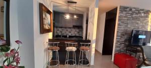 una cocina con barra con taburetes. en Espectacular apartamento de 3 habitaciones con piscina y parqueadero privado Excelente Relacion Precio Calidad Puntaje en Girardot