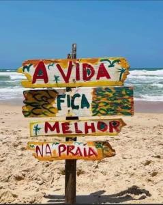 a street sign on a beach with the ocean at Apt. aconchegante Melhor Localização do Centro: conforto e praticidade in Porto Seguro