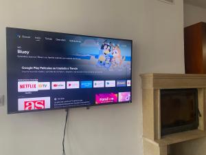 un téléviseur à écran plat accroché au mur dans l'établissement Apto en Campo Valle de Benasque 2 dormitorios Wifi, à Campo 7 autres photos