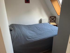 a bedroom with a bed with a blue blanket at Appartement en centre ville pour 4 personnes in Roye