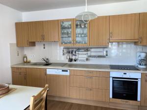 uma cozinha com armários de madeira e uma bancada em Résidence Villa Marjolaine - 3 Pièces pour 4 Personnes 734 em Pléneuf-Val-André