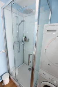 une douche avec une porte en verre à côté d'un lave-linge dans l'établissement Résidence Villa Marjolaine - 3 Pièces pour 4 Personnes 734, à Pléneuf-Val-André