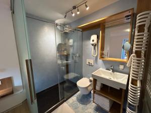 uma casa de banho com um chuveiro, um lavatório e um WC. em Apartments Mrakič em Bovec