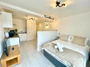 a bedroom with a large bed and a kitchen at April Disc - Long Stay - Contractors in Swindon