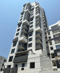 un edificio de apartamentos alto y blanco con balcones. en Apartamento Los Laureles Rodadero, en Santa Marta
