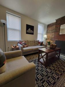 2 Bedroom East Carson Street Sanctuary في بيتسبرغ: غرفة معيشة مع أريكة وطاولة