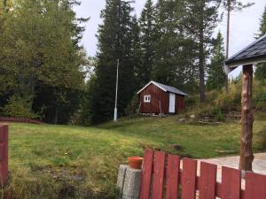 un fienile rosso in un campo vicino a una recinzione di Selmoen by Norgesbooking - secluded location a Fannrem