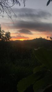 a sunset over a golf course with the sun setting at Sítio por do Sol - Pedra Azul - ES in Pedra Azul