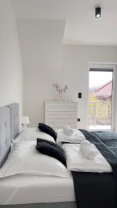 uma cama branca com duas almofadas num quarto em Apartament Lux SunRise em Żywiec
