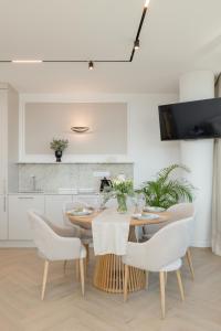 a kitchen and dining room with a table and chairs at Wave Międzyzdroje Luxury Apartment MORENORENT in Międzyzdroje