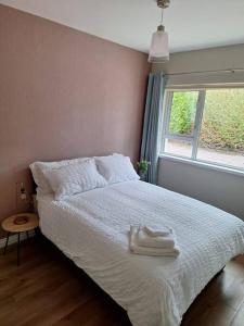 1 dormitorio con 1 cama blanca y ventana en 'Grange Hideaway' Town Centre (Sleeps 6), en Omagh