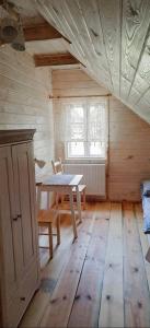 een houten kamer met een tafel en een raam bij Gościniec Pod Dębami I 