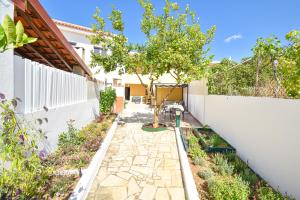 a garden with a white fence and a stone walkway at Casa dos Avós in Albufeira