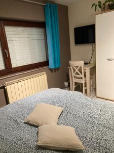 ein Schlafzimmer mit einem Bett mit zwei Kissen darauf in der Unterkunft B&B Haus Jola in Nidrum