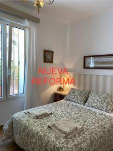 a bedroom with a bed with towels on it at PLENO CENTRO COMILLLAS-3 Hab, 2 Baños in Comillas