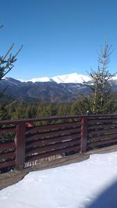 a wooden fence with a view of snow covered mountains at Rusticanna in Ranca