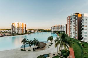 uma grande piscina com palmeiras e edifícios em Dream Lagoons Cancun Requiem em Cancún