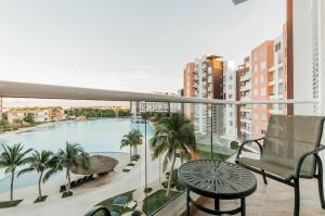 balkon z widokiem na basen i palmy w obiekcie Dream Lagoons Cancun Requiem w mieście Cancún