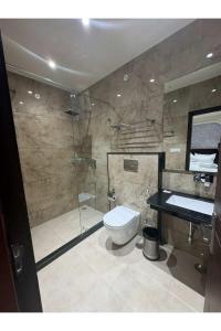 a bathroom with a shower and a toilet and a sink at Hotel Jaipur Dreams in Jaipur