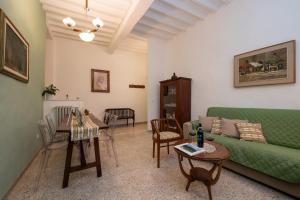 uma sala de estar com um sofá verde e uma mesa em Casa di Lara - Nel cuore della città em Montepulciano