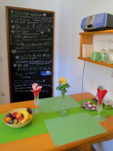 einen Tisch mit einer Schale Obst und einer Tafel in der Unterkunft Ferienwohnung/Monteurwohnung Meiser in Lambrecht