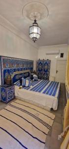 a bedroom with a bed with blue and white at Riad Osawa in Marrakech