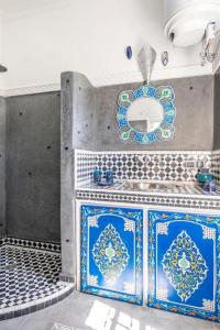 Baño con azulejos azules y blancos en la pared en Riad Osawa, en Marrakech