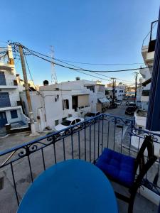 une chaise bleue assise au-dessus d'un balcon dans l'établissement Gyzi 's house, à Tinos