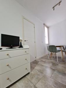 a bedroom with a dresser with a tv and a table at San Buenaventura Vistillas apartamento para dos in Madrid
