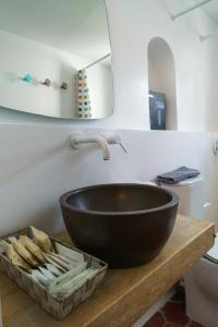 lavabo en el baño con un tazón negro sobre una mesa de madera en Livin Hydra Private Collection Suite 1, en Hydra