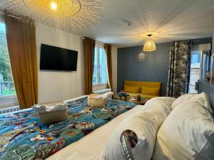 a bedroom with a large bed and a tv at Maison des Dunes in Erdeven