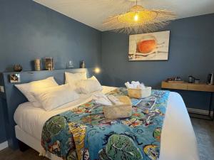 a bedroom with a bed with a blue wall at Maison des Dunes in Erdeven