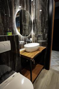 a bathroom with a sink and a mirror at B.G Luxury Suites in Korçë