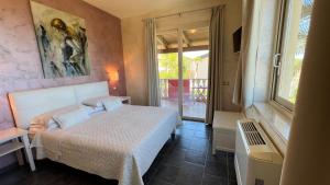 ein Schlafzimmer mit einem Bett und einem großen Fenster in der Unterkunft Borgo di Santa Barbara in Santa Domenica