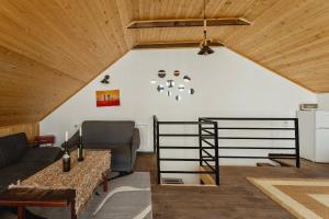 ein Wohnzimmer mit einem Sofa und einem Tisch in der Unterkunft Nectar Villa Mukhadtskaro / ვილა ნექტარი მუხადწყარო in Mzcheta