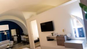 a living room with a tv on a wall at Notti d'Autore Suites in Catania