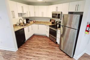 a kitchen with white cabinets and a stainless steel refrigerator at The Lofts on Clematis 404 Downtown West Palm Beach in West Palm Beach