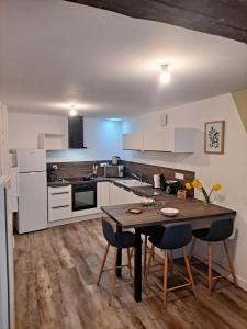 eine Küche mit einem Tisch und Stühlen im Zimmer in der Unterkunft logement T2 neuf - centre-ville in Parthenay