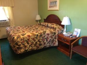 a hotel room with a bed and a table with a telephone at Howards Motel in Marshall