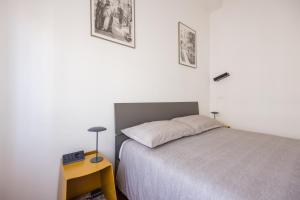 a bedroom with a bed and a table with a lamp at Memo Apartment in Bologna