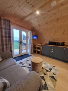 a living room with a couch and a table at Lois' Pod with Hot Tub, Near Airport in Bristol
