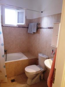 a bathroom with a toilet and a tub and a sink at LARINAKI'S STUDIO No2 in Amorgos
