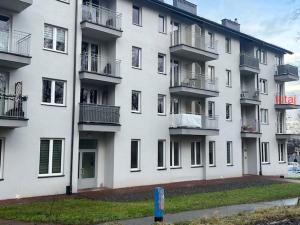 a large white building with balconies on the side of it at Mieszkaj U Marty w GRÓDKU in Jaworzno