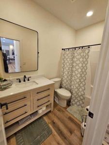ein Badezimmer mit einem Waschbecken, einem WC und einem Spiegel in der Unterkunft Silver Lake & Dunes Dream House in Mears