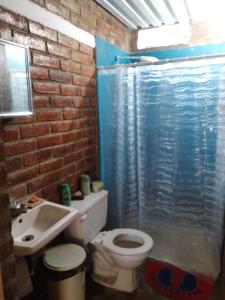 a bathroom with a toilet and a sink at Casa Vieja Surf Spa Mizata in La Libertad
