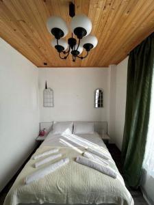 - une chambre avec un grand lit et un plafond en bois dans l'établissement Nectar Villa Mukhadtskaro / ვილა ნექტარი მუხადწყარო, à Mtskheta