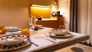 a table with bowls and plates and glasses on it at Notti d'Autore Suites in Catania