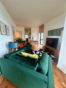 a living room with a green couch and a television at NEW Two Bedroom Apartment with Balcony in London
